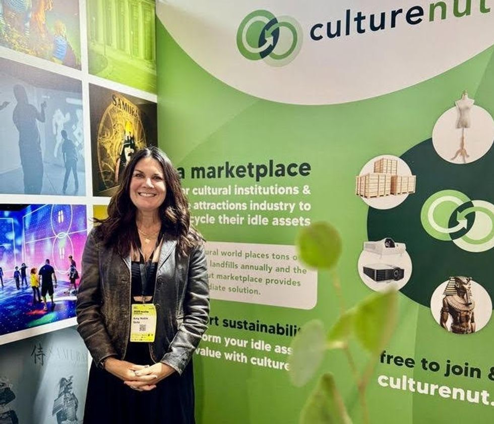 Woman smiling in front of CultureNut marketplace booth.