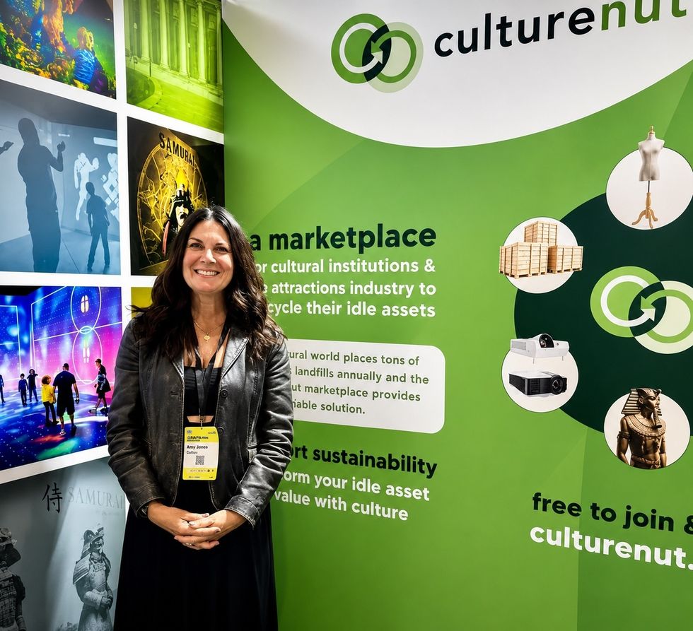Woman smiling in front of CultureNut marketplace booth.
