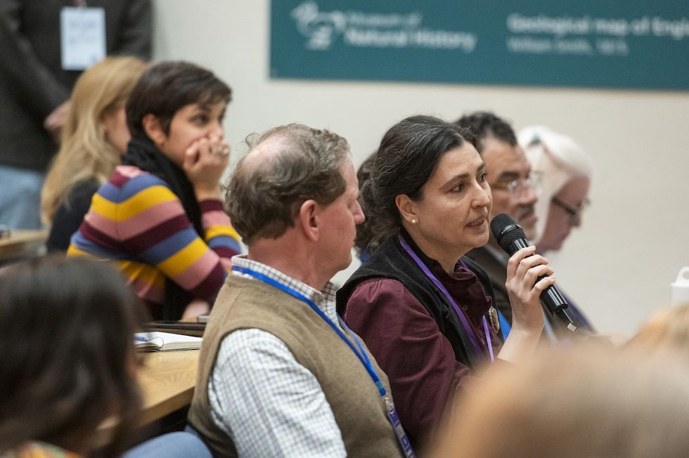 Woman speaking into microphone at a conference.