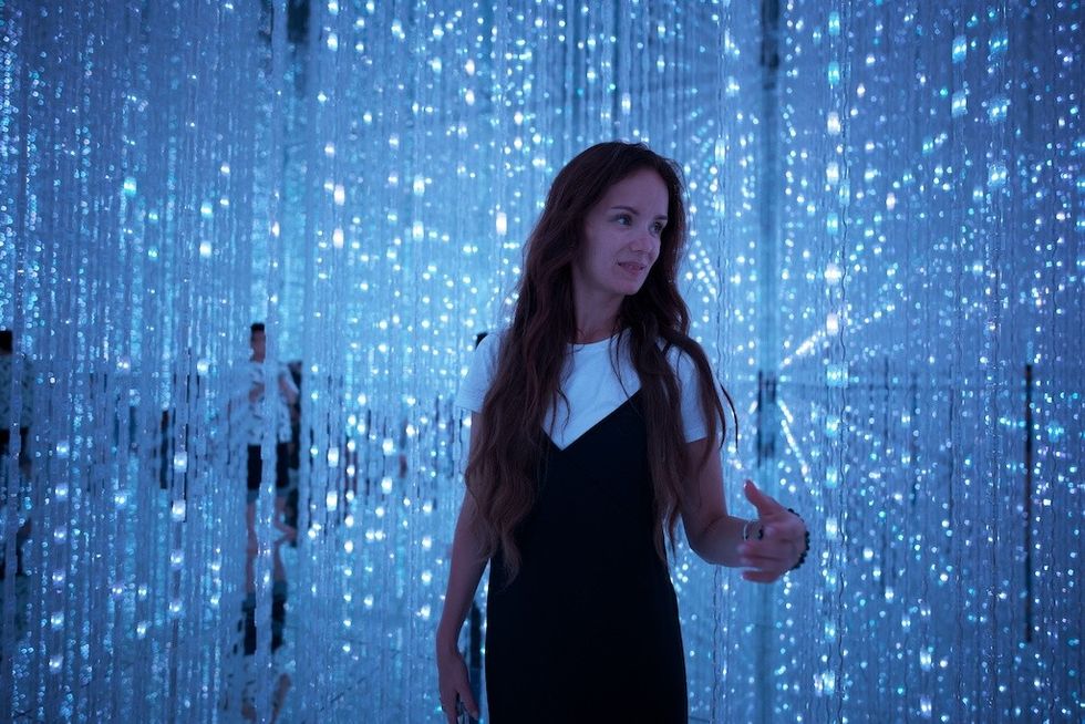 Woman standing in a room filled with cascading blue LED lights.