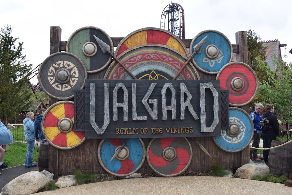 Wooden sign at Paultons Park reading "Valgard: Realm of the Vikings" with colorful shields.