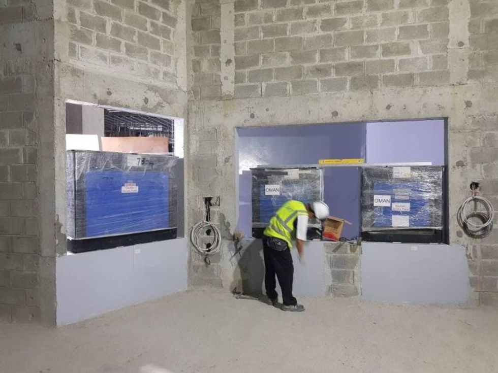 workman in hardhat installing tanks at oman aquarium