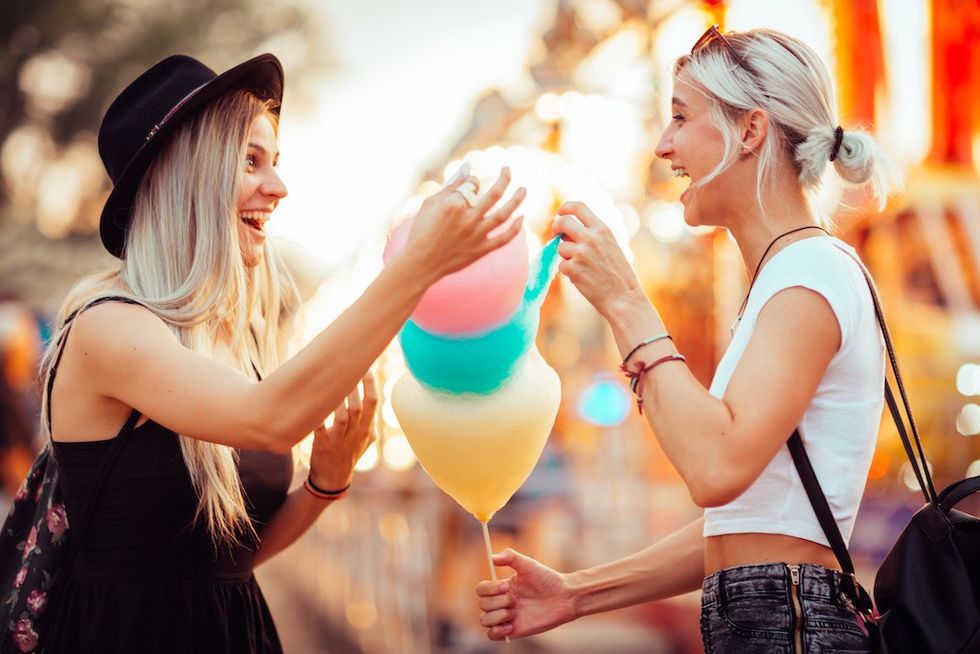 young people eating candy floss at amusement park secondary spending