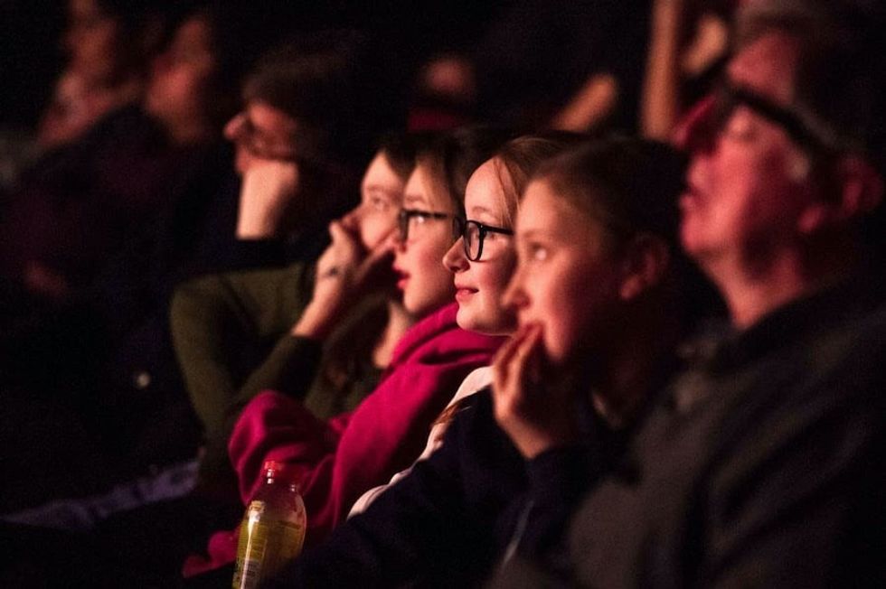 Young people in a theater watching a film