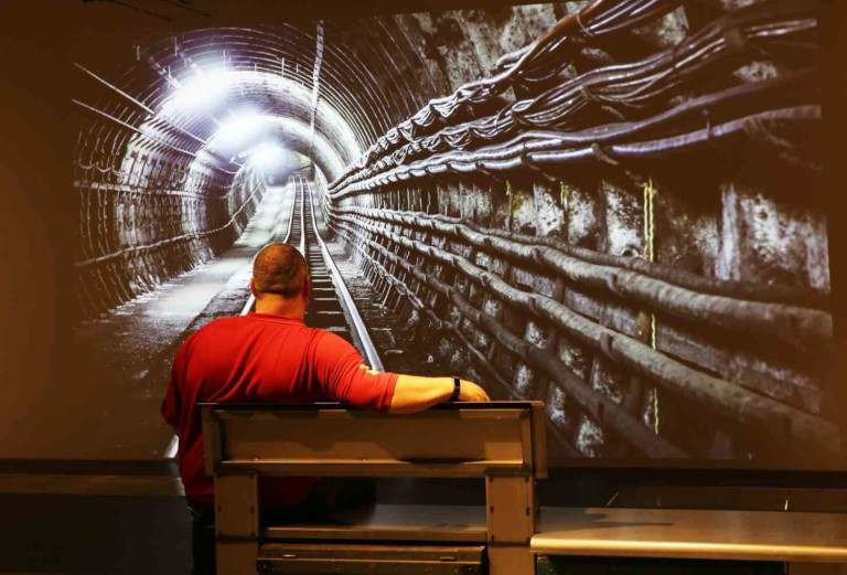 man watching digital projection mail rail tunnel