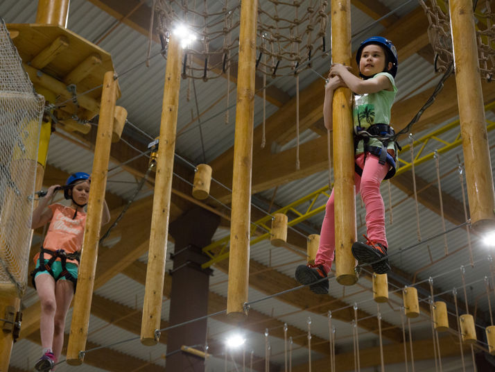 children on kanopeo aerial ropes course speedrunner belay system