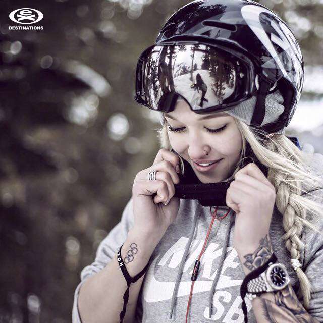 girl putting on ski helmet and goggles extreme