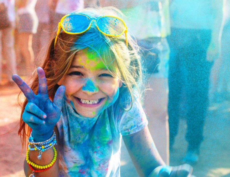 girl sprayed with paint at colour fun run pgav destinations