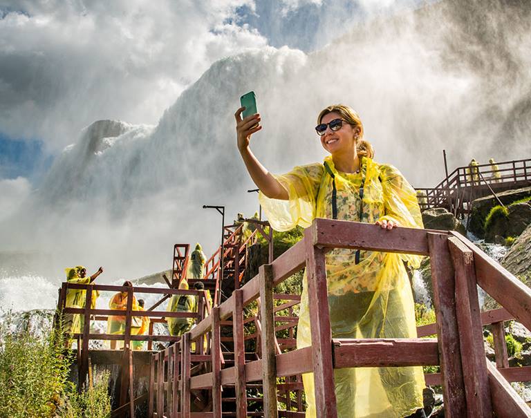 woman in poncho takes selfie at niagara falls cave of the winds