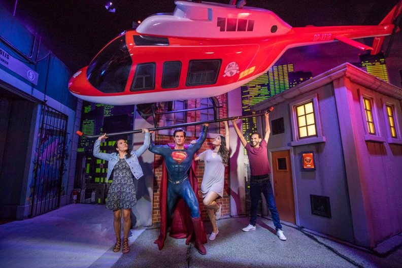 guests hold up helicopter with superman at justice league attraction madame tussauds orlando