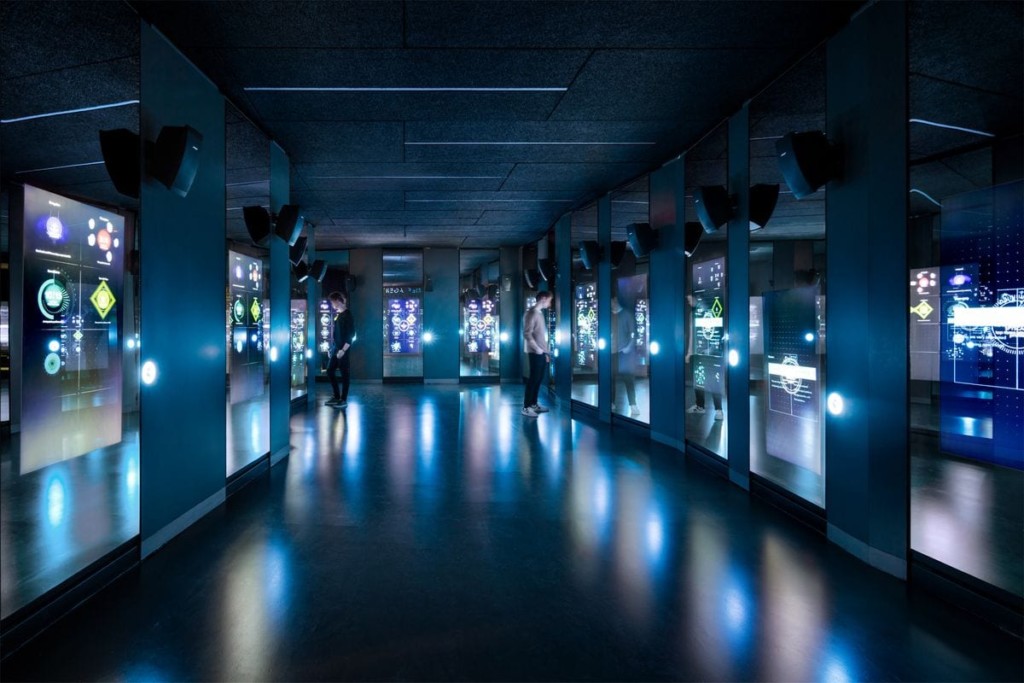 Two visitors reading the digital wall panels at the Spyscape museum