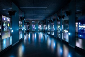 Two visitors reading the digital wall panels at the Spyscape museum