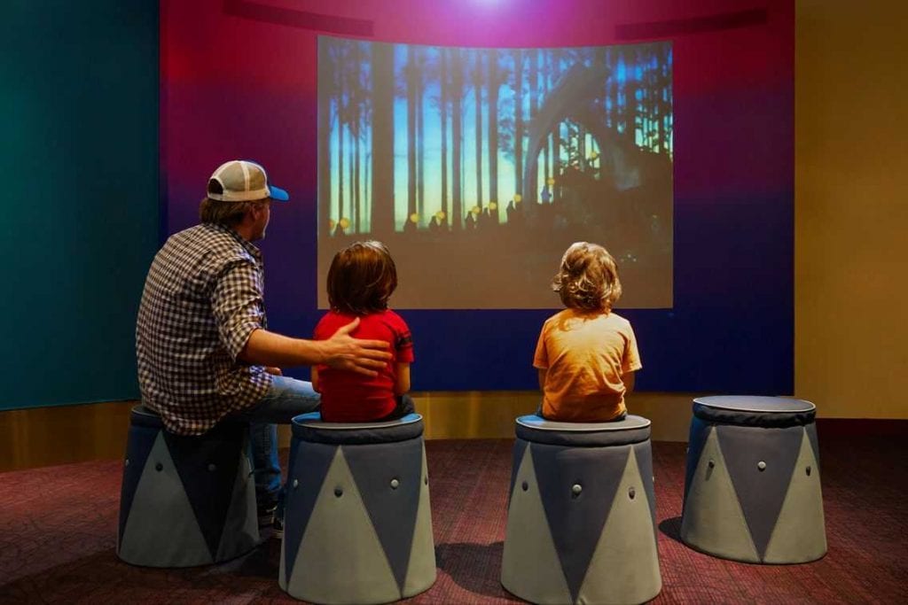 Three visitors watching an animated video at the Walt Disney Family Museum 