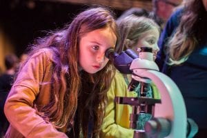 Young girl looking into a microscope at Liverpool Light Night