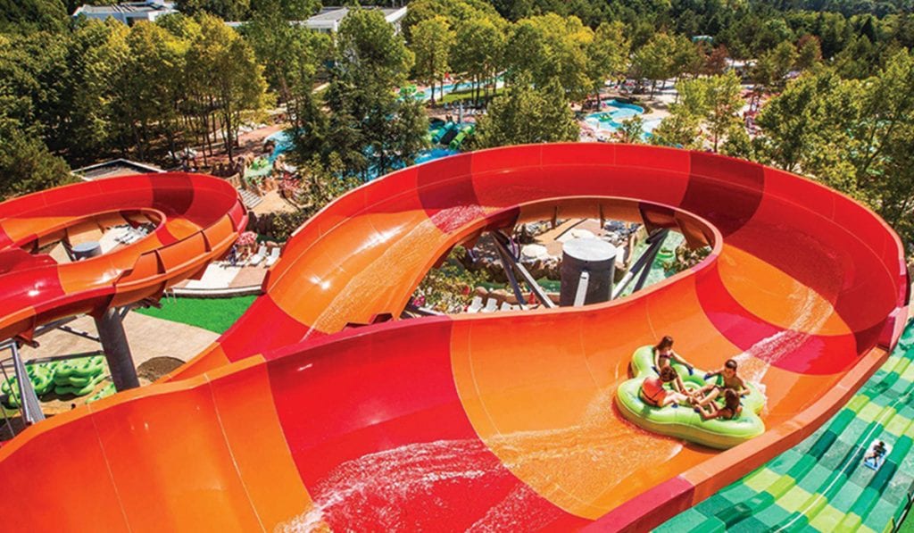 Large four person raft going down a large water slide with quick turns