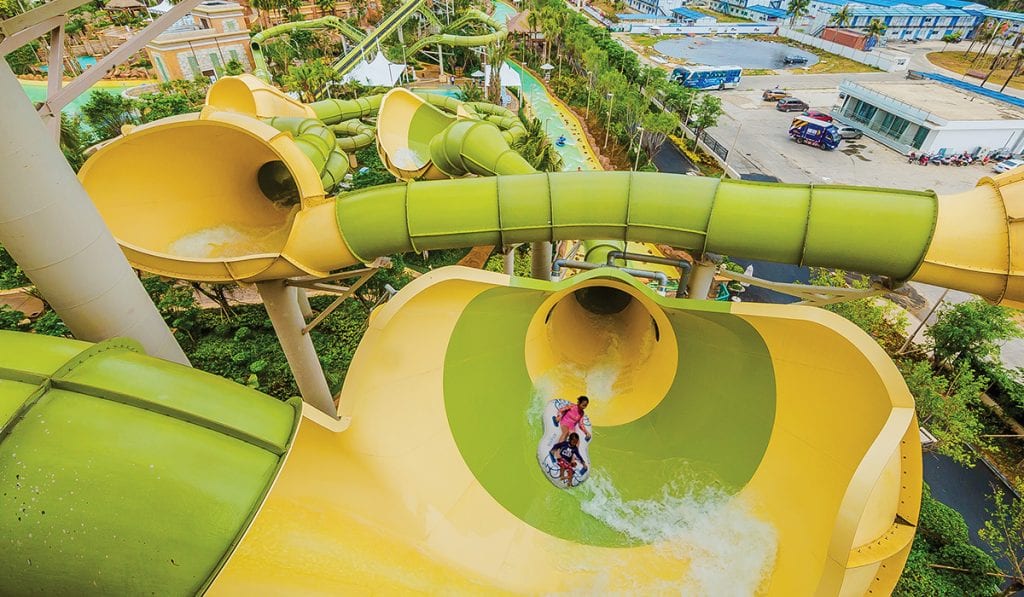 Top view of twi individuals on a raft about to enter a green and yellow Tornado 24