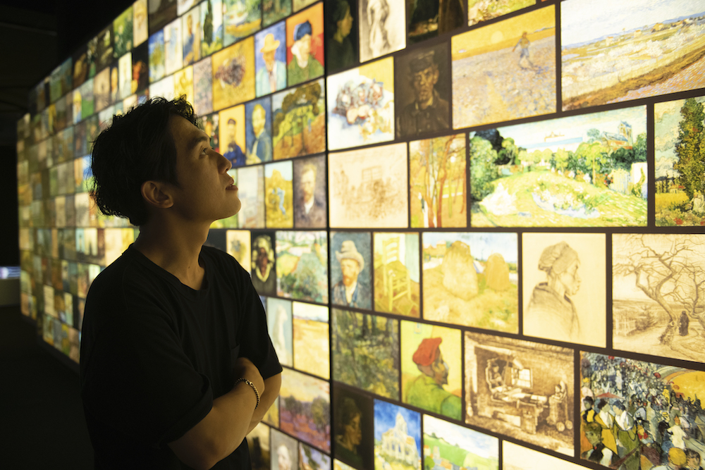 woman looking at Vincent van Gogh's paintings at travelling exhibition