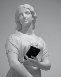 statue holding mobile phone museum