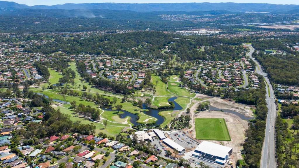 Aerial view of planned community in Gold Coast, Parkwood Village, featuring homes and sporting greens.