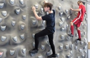 2 Children climb on a climbing wall