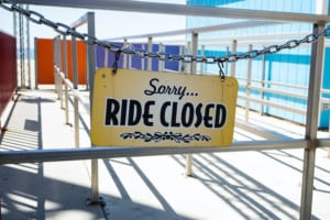 ride closed sign hanging on empty amusement park ride