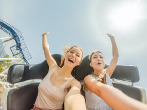 Two happy girls having fun on rollercoaster