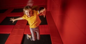 Little girl jumping on trampoline in fly park