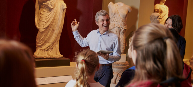 Managing the visitor experience Pupils And Teacher On School Field Trip To Museum With Guide