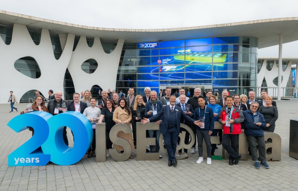ISE workers pose in front of 20 ISE sign in Barcelona
