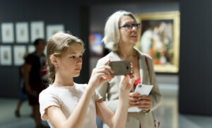 Mum and daughter in museum looking at mobile phone