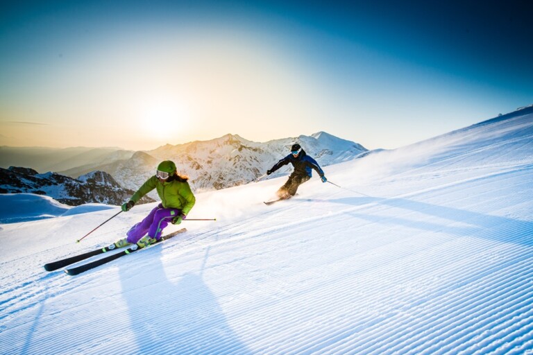 Man and woman skiing downhill