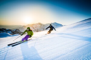 Man and woman skiing downhill